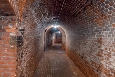 Kaliningrad, Russia - May, 2018. Long underground tunnel leading to the right with illumination. clipart