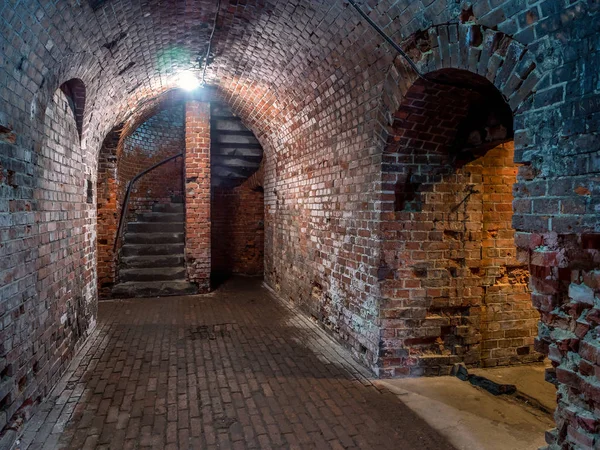 Kaliningrad, Rusya Federasyonu - 2018 olabilir. Tuğla koridor ve sonunda döner merdiven ışığında yeraltı.