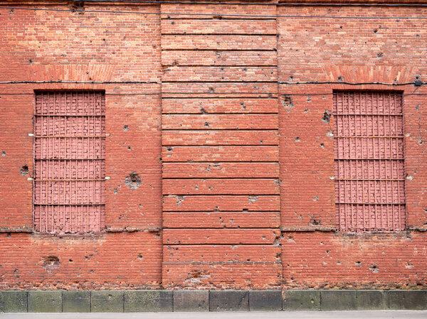 Brick wall with bullet marks.
