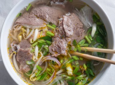Beyaz tabakta Vietnam pho-bo çorbası üst görünümü