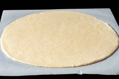 bir fırın kağıdı üzerinde pizza tabanı