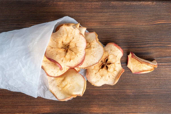 Vista superior de sabrosas papas fritas de manzana en un papel sobre el fondo de madera. Enfoque suave . — Foto de Stock