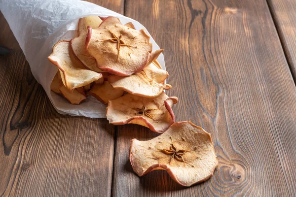 Vista de cerca de las sabrosas papas fritas de manzana en un papel en la parte posterior de madera — Foto de Stock