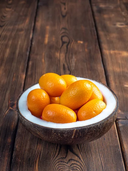 Close up view kumquat in a coconut bowl on wooden background. Ve — Stock Photo, Image