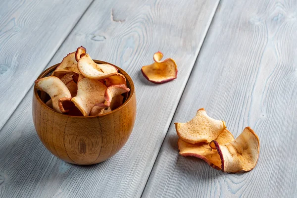 Vista de cerca de las sabrosas papas fritas de manzana en una taza de madera sobre el fondo de madera blanca. Enfoque suave . — Foto de Stock