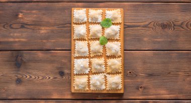 ahşap arka plan üzerinde Taze Ev Yapımı Ravioli op Görünümü. Kopyalama alanı ile.