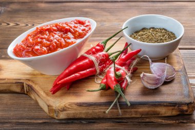 Harissa 'nın acı biber, sarımsak ve kimyon tohumlarını beyaz bir keten havlunun üzerine serpiştirdiği sos teknesinin yakın görüntüsü. Yumuşak odak.