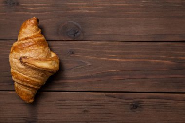 Taze kruvasan üstten görünüm koyu kahverengi ahşap tablo