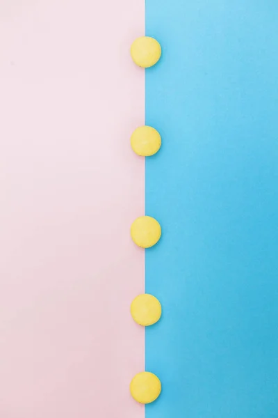 yellow french macaroons on blue and pink background