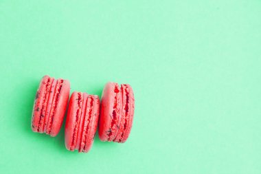 Yeşil arka plan üzerinde üç kırmızı macaroons