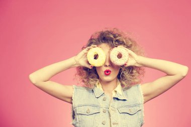 çörek, pembe arka plan izole gözleri önünde tutan kız