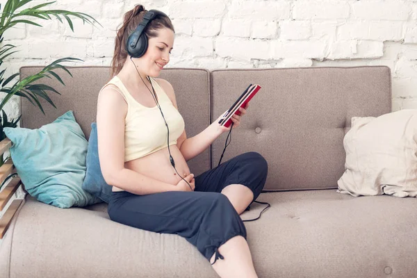 Kanepede Oturan Müzik Dinlerken Güzel Hamile Kız — Stok fotoğraf