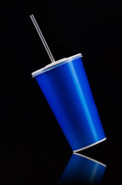 Siyah arka planda izole kapak ve tüp ile mavi fincan