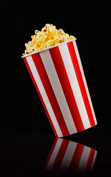 Cubo a rayas de papel con palomitas aisladas sobre fondo negro —  Fotos de Stock