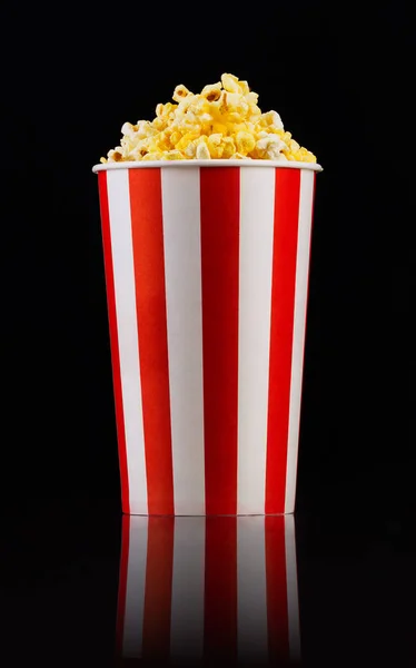 Cubo a rayas de papel con palomitas aisladas sobre fondo negro —  Fotos de Stock