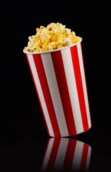 Cubo a rayas de papel con palomitas aisladas sobre fondo negro —  Fotos de Stock