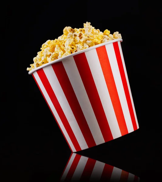 Cubo a rayas de papel con palomitas aisladas sobre fondo negro —  Fotos de Stock