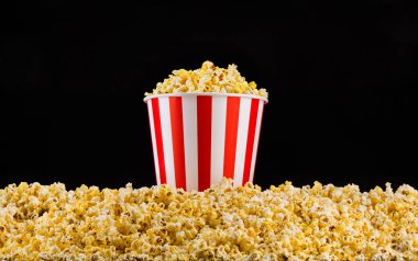 Kağıt çizgili kova yüklü dağınık Popcorn siyah arka planda izole