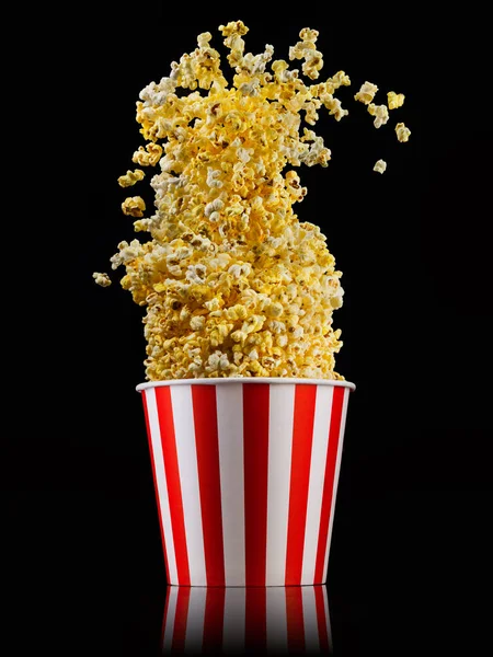 Palomitas voladoras de cubo a rayas aisladas sobre fondo negro —  Fotos de Stock