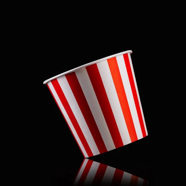 Empty popcorn striped bucket isolated on black background — Stock Photo, Image