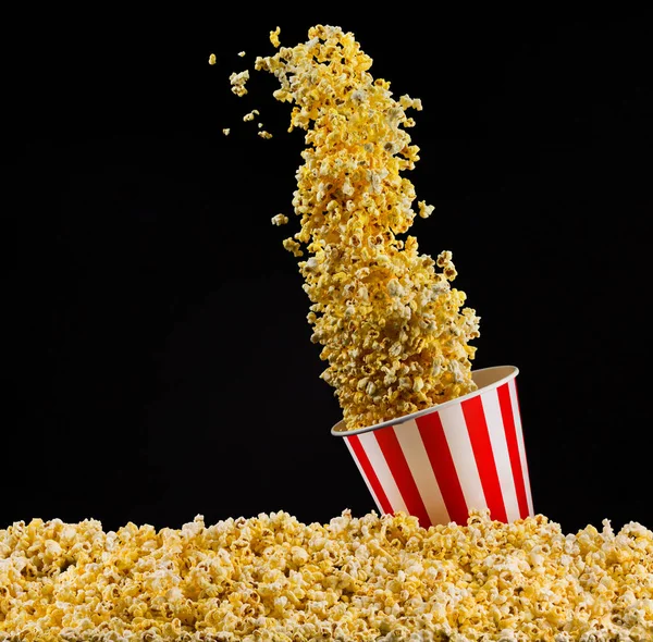 Siyah arka plan üzerinde izole çizgili kova uçan patlamış mısır