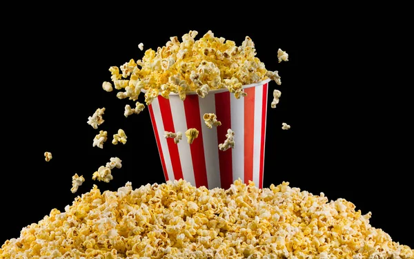 Flying popcorn from striped bucket isolated on black background