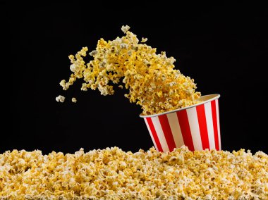 Siyah arka plan üzerinde izole çizgili kova uçan patlamış mısır