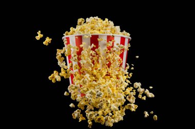 Siyah arka plan üzerinde izole çizgili kova uçan patlamış mısır