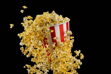 Siyah arka plan üzerinde izole çizgili kova uçan patlamış mısır