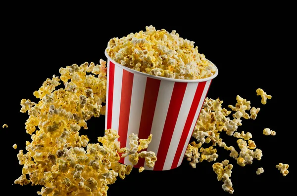 Popcorn volanti da secchio a strisce isolato su sfondo nero — Foto Stock