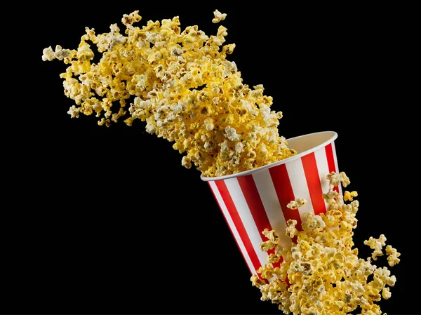 Popcorn volant à partir de seau rayé isolé sur fond noir — Photo