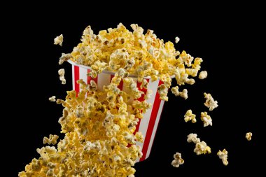 Siyah arka plan üzerinde izole çizgili kova uçan patlamış mısır