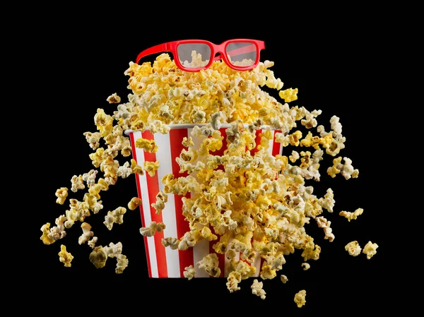 Flygande popcorn från randig hink isolerad på svart bakgrund — Stockfoto