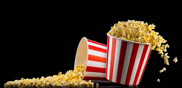 Uppsättning av papper randiga skopor med popcorn isolerad på svart bakgrund — Stockfoto