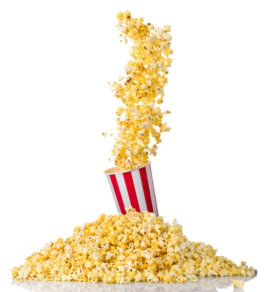 Létající popcorn z papírově pruhovaného kbelíku a roztroušeného popcornu izolovaného na bílém — Stock fotografie