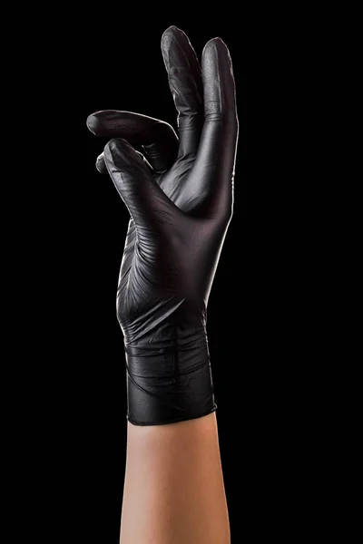 Hand in Hand mit schwarzen Handschuhen, die etwas Isoliertes auf schwarzem Hintergrund aufnehmen oder zeigen — Stockfoto