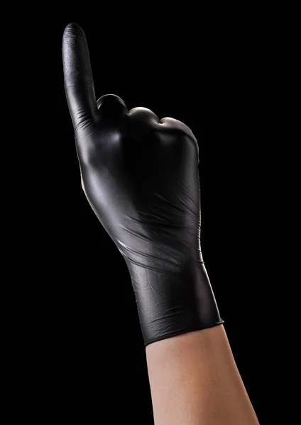 Main en gants noirs avec index pointant vers le haut sur noir — Photo