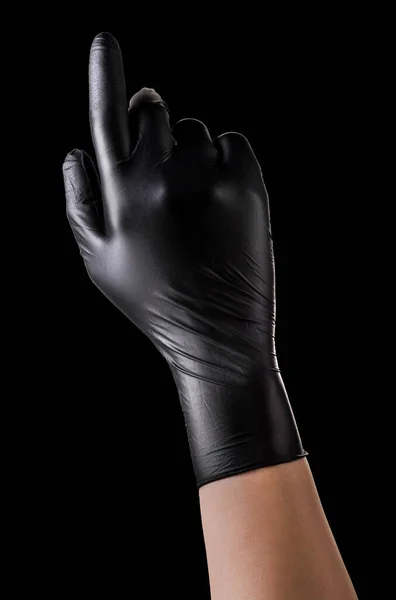 Main en gants noirs avec index pointant vers le haut sur noir — Photo