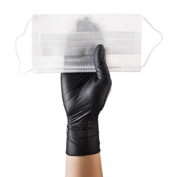Χέρι σε μαύρα γάντια που κρατούν μάσκα προσώπου μίας χρήσης απομονωμένη σε λευκό φόντο — Φωτογραφία Αρχείου