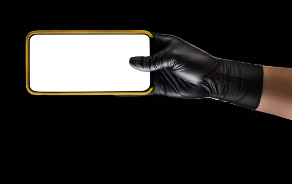 Mano in guanto nero che tiene il telefono cellulare con schermo vuoto isolato su nero — Foto Stock