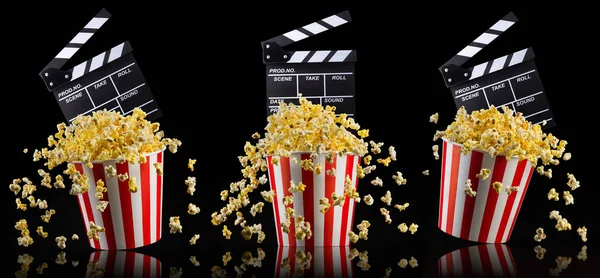 Flygande popcorn och film clapper styrelse isolerad på svart bakgrund — Stockfoto