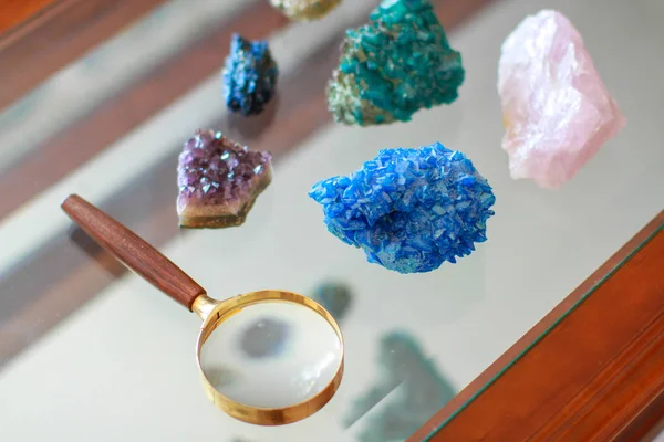 Loupe entouree de pierres prcieuses et poz une une table in verre 