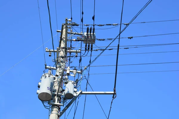 Pilão de transmissão de eletricidade contra o céu azul — Fotografia de Stock
