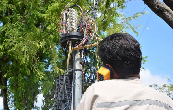 Técnico está conectando um cabo de rede para a tomada de linha . — Fotografia de Stock