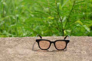 arka planda bir orman ile bir park bankı veya masada hipster gözlük