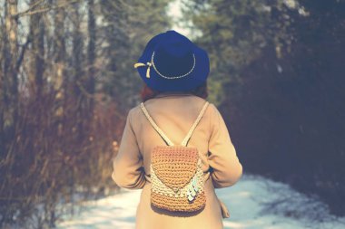 Kışın ormanda yürüyen kadın.