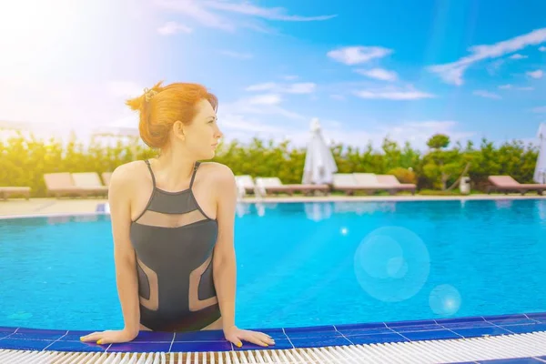 La jeune fille se dégage de la piscine. — Photo