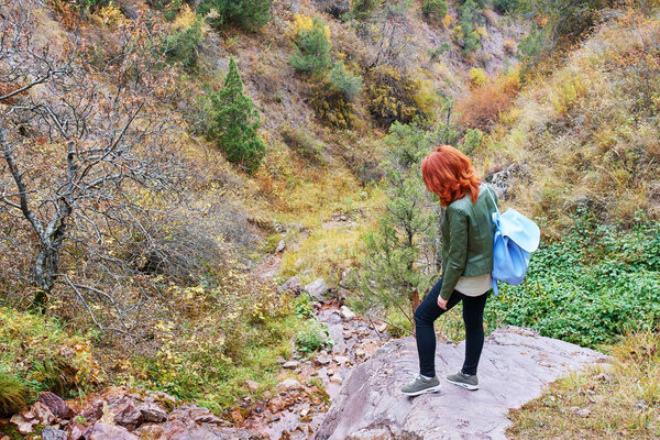 Female hiker walking in mountains forest. 
