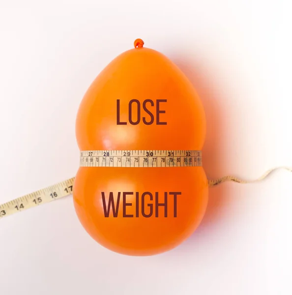 Idea of weight loss. Balloon with measuring tape. Lose weight text