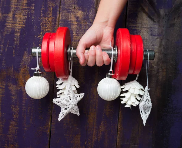Noel ve yeni yıl menekşe ahşap arka plan üzerinde. Sağlıklı yaşam ve spor için dumbbells ile kompozisyon